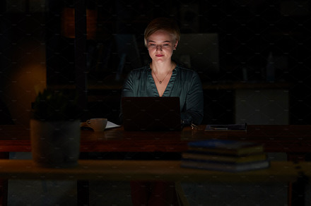 Night, laptop and concentrating with woman in office for planning, overtime or corporate mockup. Strategy, technology and email with employee typing proposal at desk for proposal, trading or internet, a Photo by Peopleimages.com