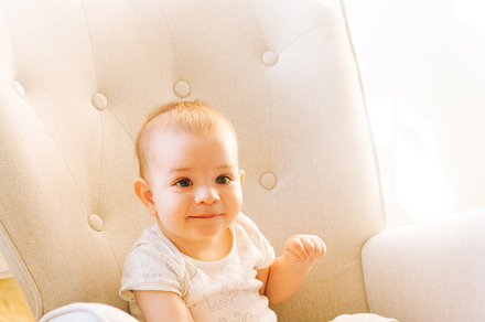Portrait of a nine month old baby sitting in a rocking chair
