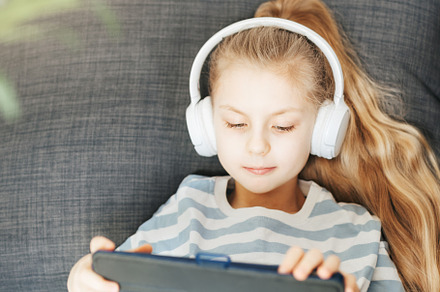 Little girl with headphones and tablet  at home, a Person Photo by Olena Rudo