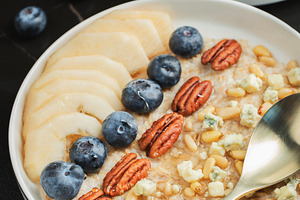 Oatmeal. Bowl of oatmeal porridge with blackberry, bananas and chia seeds on gr, a Food & Drink Photo by Budarinphoto