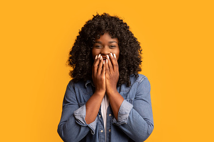 Shocked black woman covering her mouth with hands, a Background Photo by Prostock-Studio