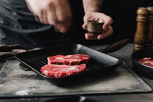 Butcher cooking beef steaks