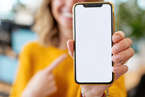 Woman showcases blank smartphone screen in a modern office setting during work, a Person Photo by AlyaAnd