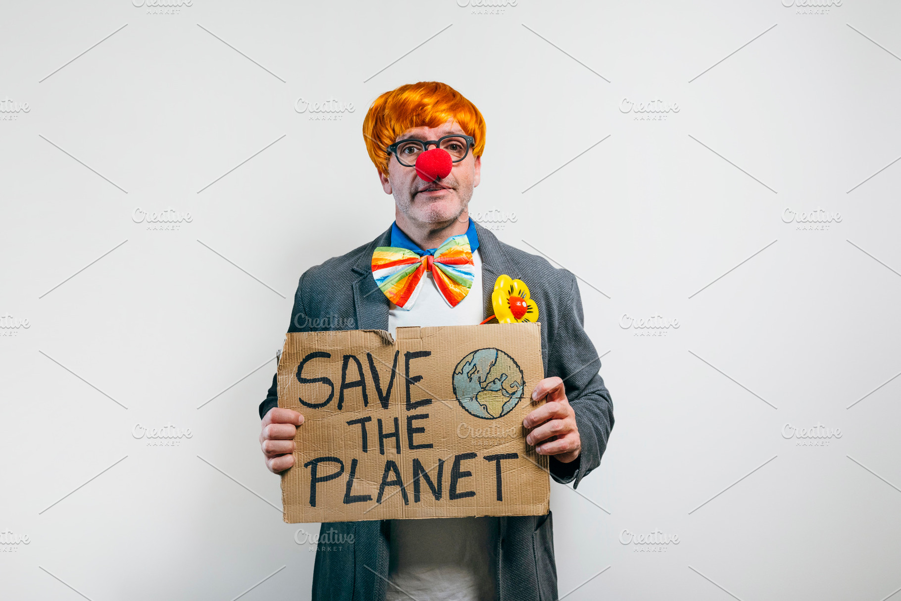 Clown holding save the planet sign on white background, a Person Photo by karrastock