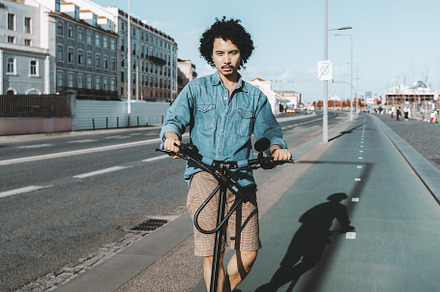 Man on e-scooter in urban settings, a Person Photo by SkyNext