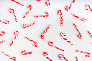 Candy cane sweets on white background, simple pattern, layout, a Holiday Photo by Rimma