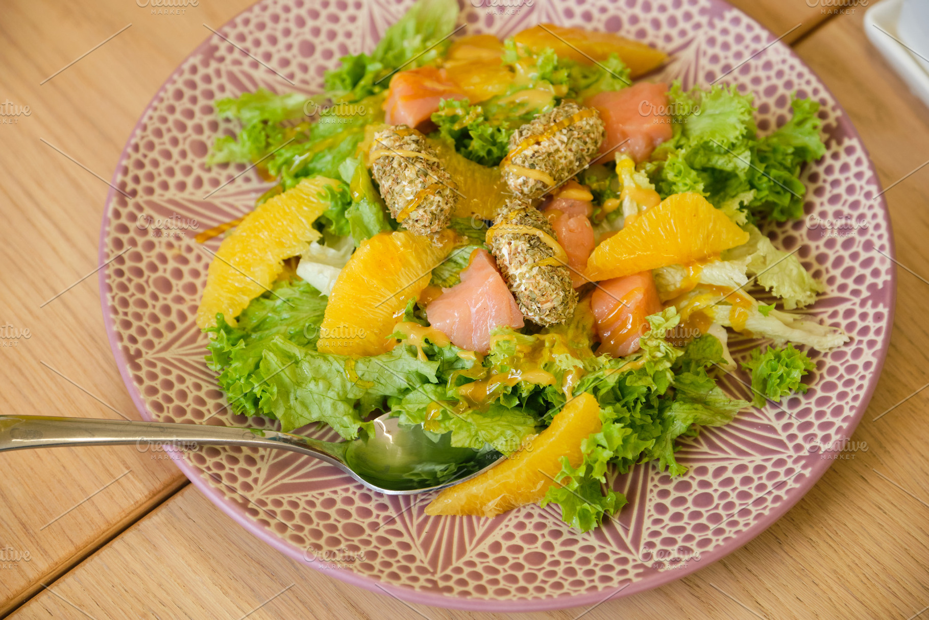Healthy salad with salmon, orange slices and herbal cheese balls on a decorativ, a Food & Drink Photo by Rohan Photography