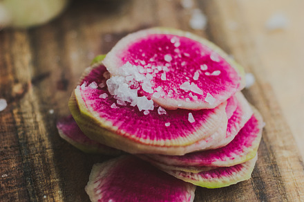 Watermelon radishes sliced sprinkled with sea salt on a wooden background, a Food & Drink Photo by sponge_po