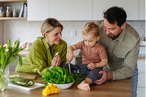Family preparing lettuce salad to, a Food & Drink Photo by HalfPoint