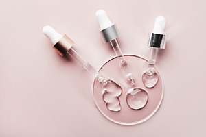 Three pipettes with different samples of gels cosmetic products in petri dish o