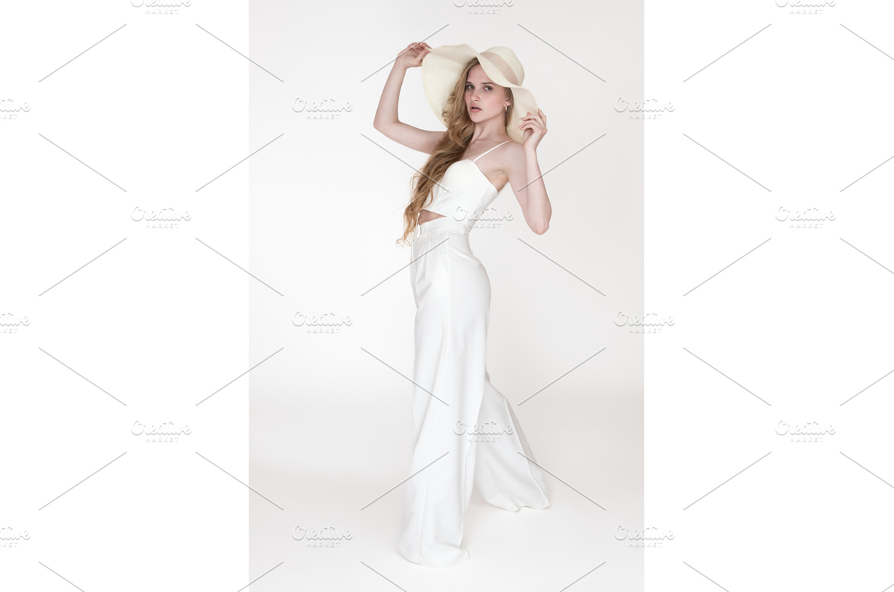 Model holding brim of straw hat with, a Person Photo by Alexander-Piragis