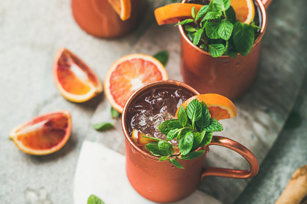 Blood orange Moscow mule alcohol cocktails over concrete background, a Food & Drink Photo by Foxys