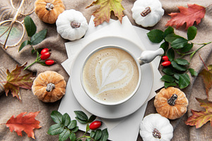 Autumn latte art heart with fall pumpkins and leaves
