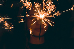 Girl holding sparkler featuring silhouette, black, and dark