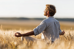 Man meditates peacefully on a field, a Person Photo by MistyDay