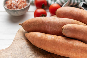 Sweet potatoes on cutting board with kitchen ingredients, a Food & Drink Photo by Olena Rudo