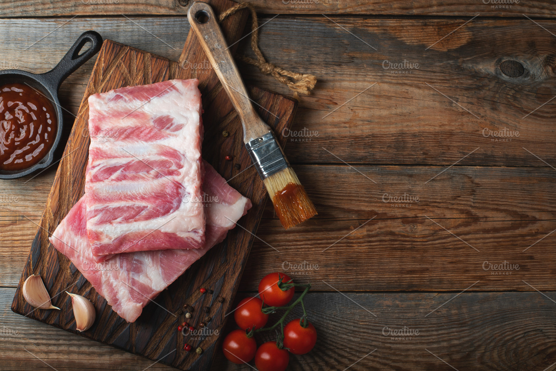 Raw pork ribs with spices, salt and rosemary on dark wooden background, a Food & Drink Photo by Budarinphoto