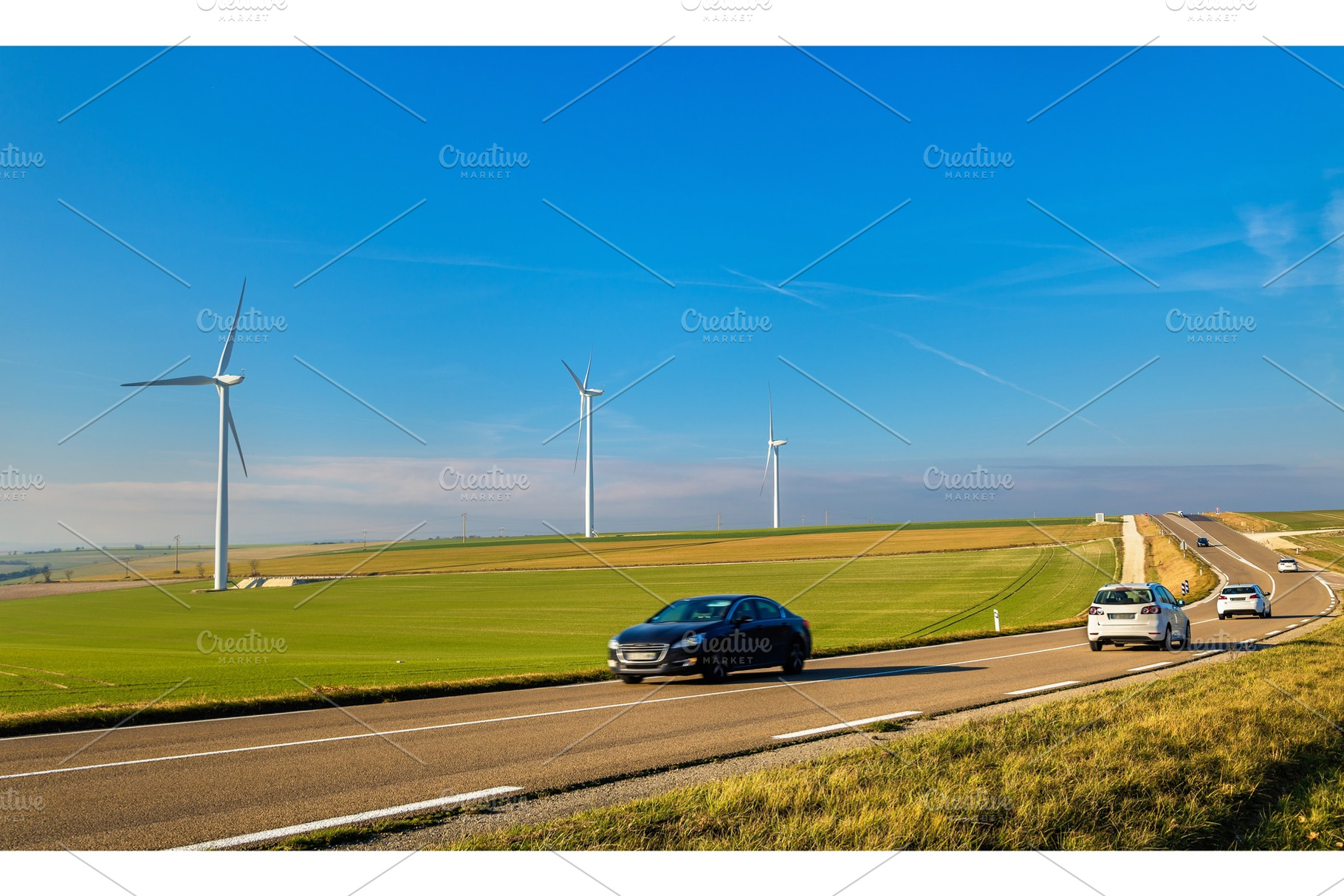 Cars on a highway and wind turbines in the background - France, a Transportation Photo by Leonid Andronov