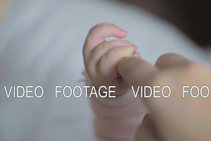 Baby daughter holding mum finger