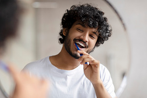 Oral care concept. Young indian man cleaning teeth with toothbrush, smiling to, a Person Photo by Prostock-Studio