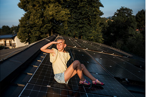 Girl sitting on roof with solar, a Technology Photo by HalfPoint