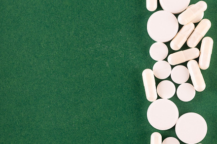 many different blisters with tablets on green background. Assort, a Health & Medical Photo by vimart