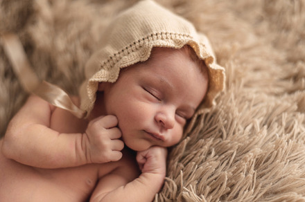A newborn baby Sleeping peacefully in a brown hat. Newborn Session Concept, a Person Photo by YossSabalet