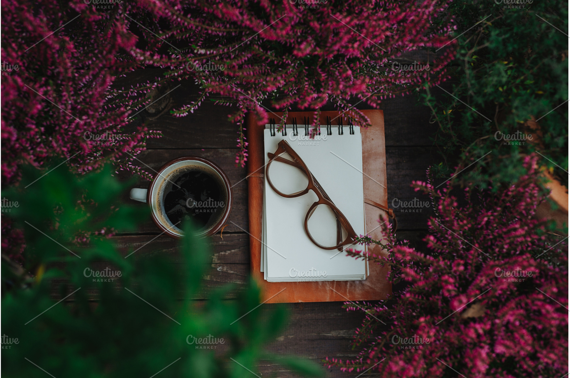 Reading glasses resting on notebook, a School & Education Photo by HalfPoint