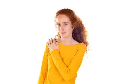 Young redhead woman suffering of backache, touching her shoulder, a Person Photo by José Manuel Gelpi