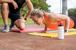 Personal trainer coaching woman doing push ups during outdoor fitness workout, a Sports & Recreation Photo by etorres69