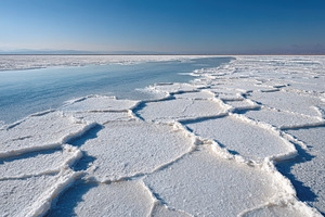 Frozen salt flat with blue water channel, a Nature Photo by AlyaAnd