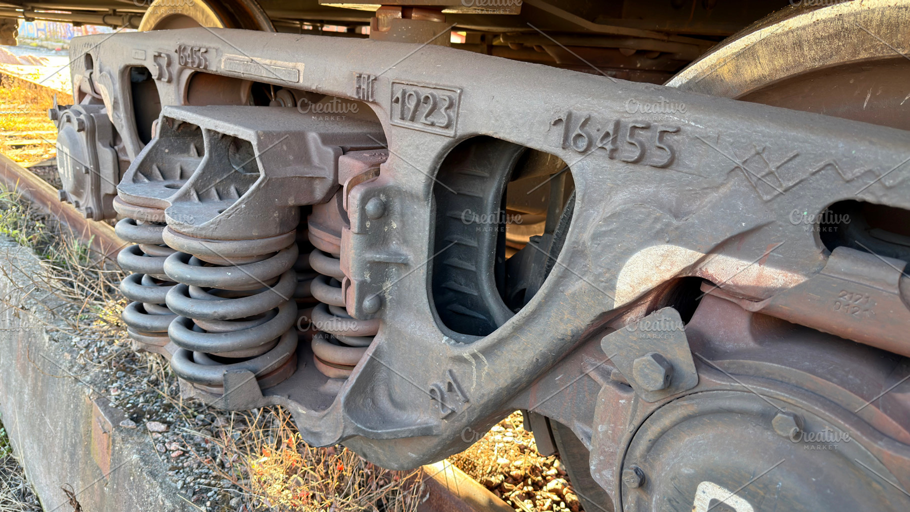 Close-up of a train wheel assembly showcasing springs and metal components, an Industrial Photo by Textures & Backgrounds