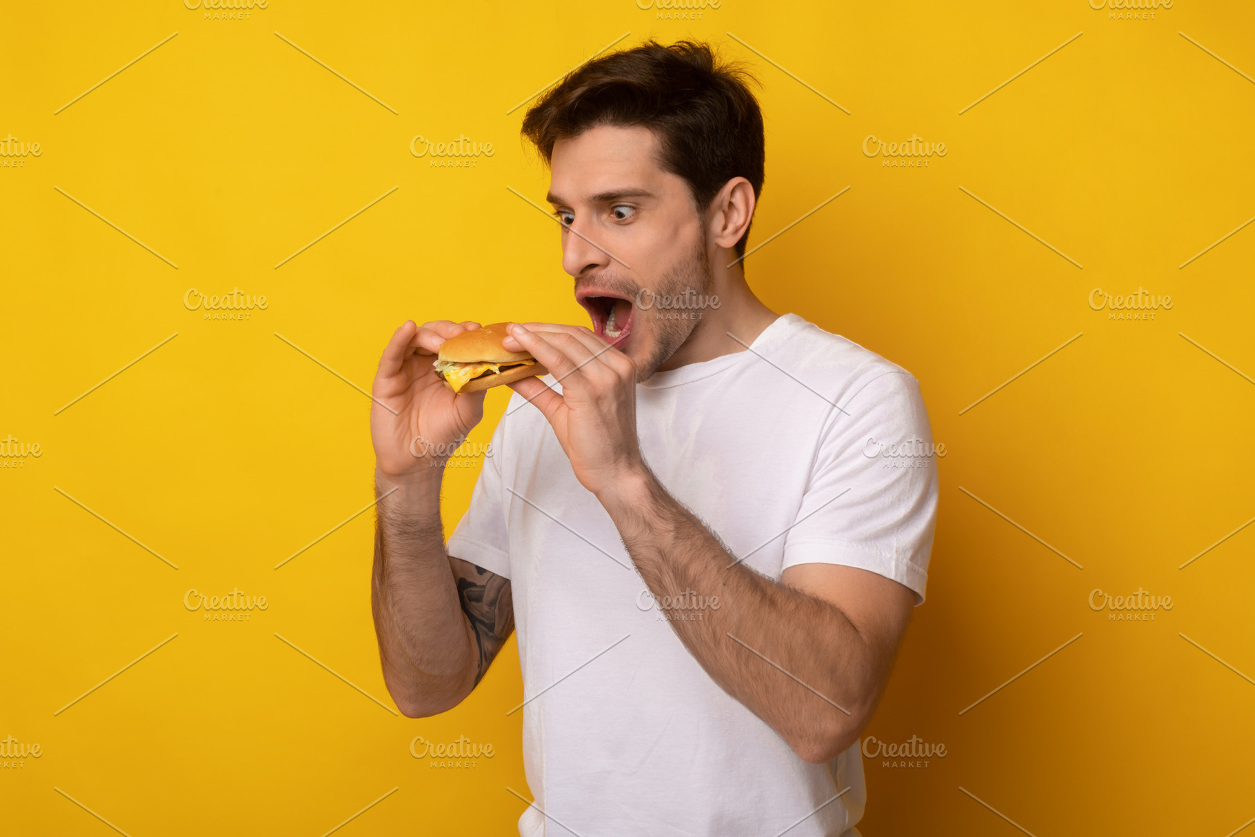 Funny Guy Holding Burger Craving Sandwich At Studio, a Photo by Prostock-Studio