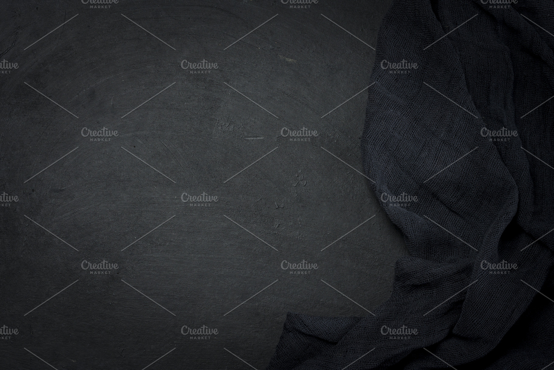 Folded black gauze kitchen napkin on black table, top view, a Background Photo by ndanko