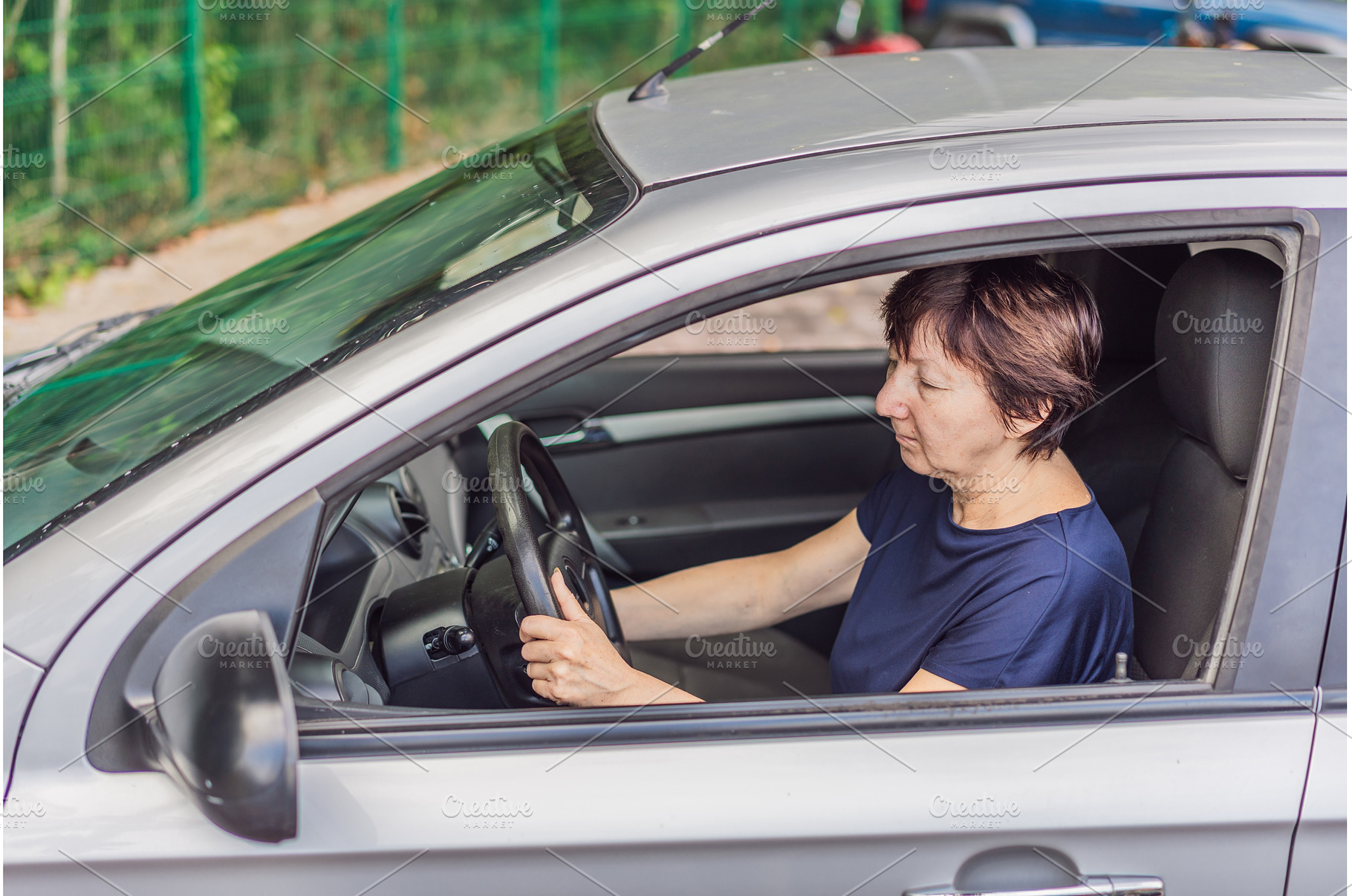 Older woman driving a car with focus, a Transportation Photo by Elizaveta Galitskaya
