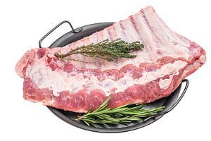 Pork spareribs raw whole rack with garlic and herbs in tray flat