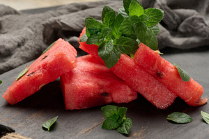 Fresh watermelon sliced into triangles with mint leaves on, a Food & Drink Photo by ndanko