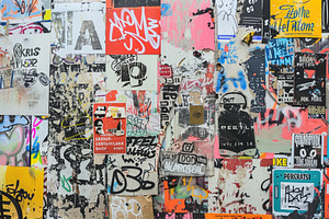 A Vibrant Collage Of Various Stickers And Graffiti On A Wall, Showcasing A Mix