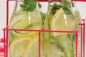 Glass bottles with red lids filled with detox water containing c, a Food & Drink Photo by ndanko