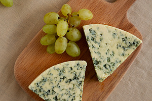 Delicious Cheese Danablu on a wooden board, top view., a Food & Drink Photo by LiudmylaChuhunova