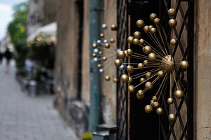 Golden decorative design element on outdoor railing in urban street setting, a Photo by AS photostudio