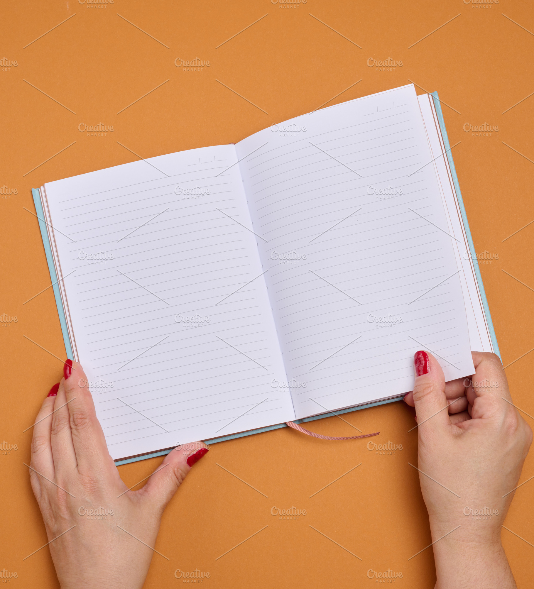 Female hands holding an open notebook with clean, lined pages on, a Background Photo by ndanko