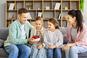 Family Sharing Strawberries on Couch