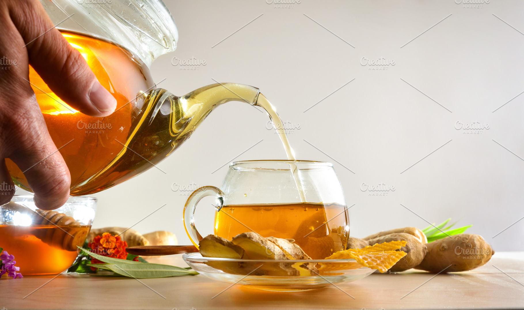 Person pouring a cup of ginger infusion from a teapot, a Food & Drink Photo by Davizro's Market