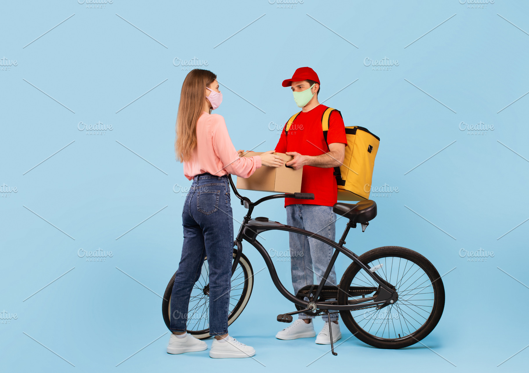 Courier Man Delivering Cardboard Box To Lady Over Blue Background, a Photo by Prostock-Studio