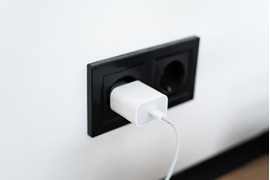 White USB charger plugged into black, a Technology Photo by volodymyrshtun13795