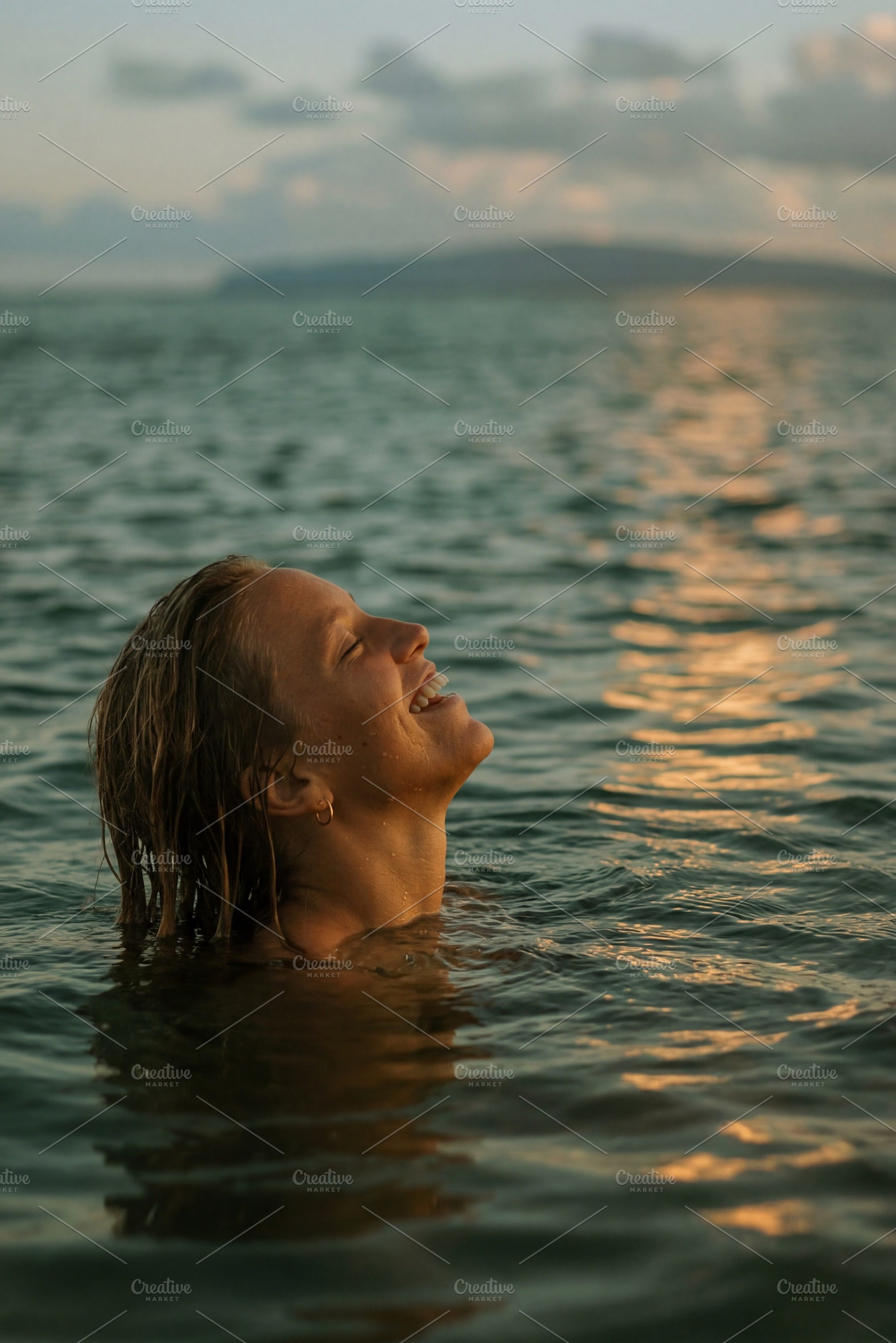 Joyful woman enjoying a sunset swim, a Beauty & Fashion Photo by Virgo Studio