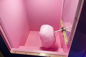Pink cotton candy in a vending machine with a vibrant and colorful background, a Photo by AS photostudio