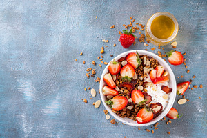 Healthy breakfast bowl with granola, yogurt and strawberry, a Food & Drink Photo by Rimma
