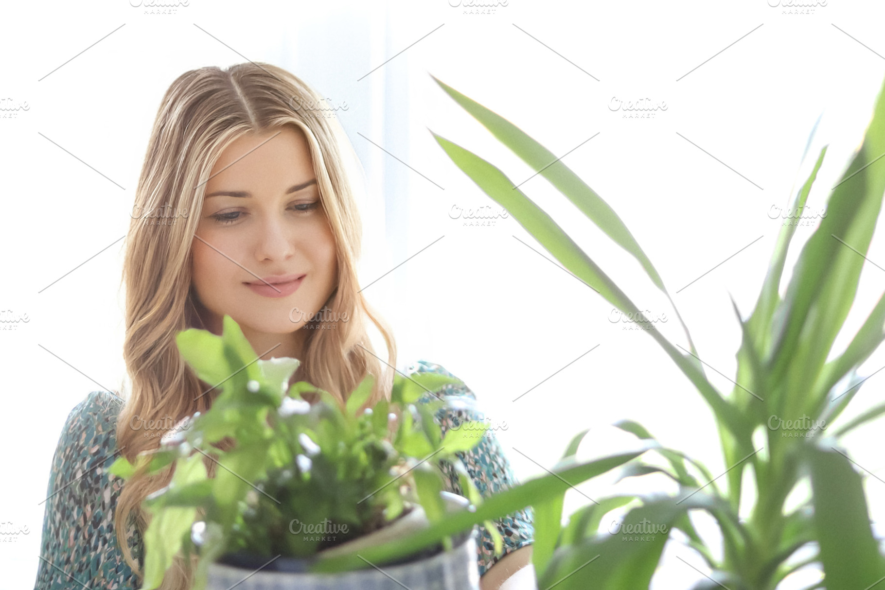 Blonde woman in a green dress looking at a houseplant with soft, a Person Photo by Studio ANNA